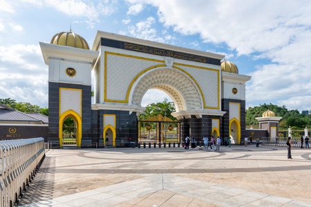 Kuala Lumpur, Malaysia - March 1, 2025: Istana Negara, or National Palace, main gate. Grand, ornate architecture with golden domes, intricate patterns, and calligraphy. Tourists gatherの写真素材