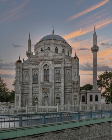 Pertevniyal Valide Sultan Mosque, Istanbul, Turkey. Historic Ottoman architecture with a prominent dome and minaret under a vibrant sunset sky.の写真素材