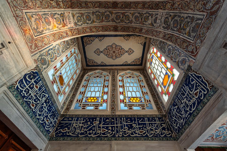 Interior of Sultan Ahmed I Tomb, Istanbul, Turkey. Features ornate Islamic patterns, colorful stained glass windows, and intricate calligraphy on blue tilesの写真素材