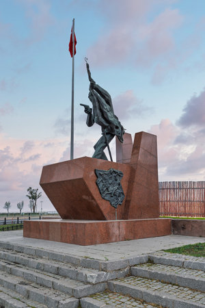 Ilk Kursun Aniti, First Shot Monument, Konak Square, Izmir, Turkey. Bronze statue on red granite with Turkish flag against a cloudy skyの写真素材