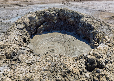 Gobustan Mud Volcano erupts with bubbling mud, surrounded by cracked dry earth in Baku, Azerbaijan....