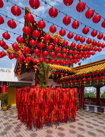 Vibrant red lanterns and prayer ribbons decorate Thean Hou Temple in Kuala Lumpur, Malaysia. A traditional Chinese temple with festive cultural elements under a clear blue skyの写真素材
