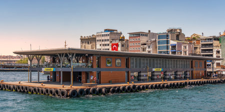 Istanbul, Turkey - June 5, 2025: Karakoy Ferry Terminal and Galata Bridge. Modern pier building on the Bosphorus, with the city skyline under a clear blue skyのeditorial素材