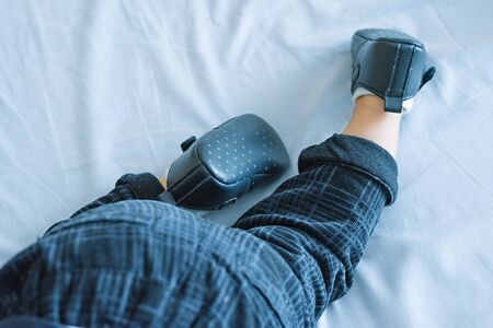 A 6 month old baby learns to crawl at home in bed. Child development concept, top to bottom, baby legs close-up
の写真素材