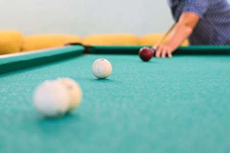 Man's hand and arm playing pool preparing to shoot the white ball of a green Pool. Russian billiardの写真素材