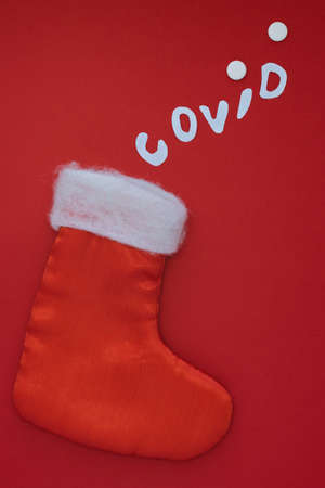 New Years boots for gifts and the inscription covid with pills on a red background. Health care...