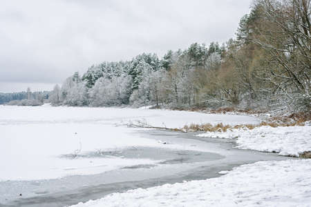 Thin ice on the river. Dangerous concept. Freezing and melting time for ice on the water reservoirs in winter.の写真素材