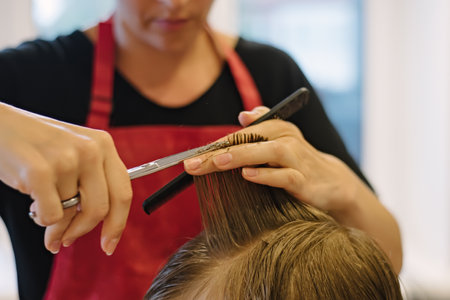 Woman cuts hair of boy at home. Homemade haircutの写真素材