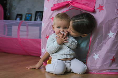 Baby playing in room with his older sister. Childhood concept