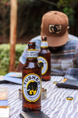 Nairobi, Kenya, July 11 2017 - Tourist enjoys the local beer Tuskerのeditorial素材