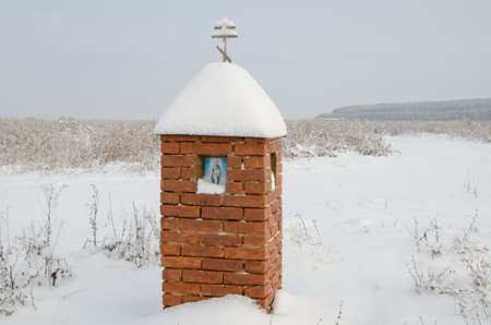 A small brick chapel in winter field.の写真素材