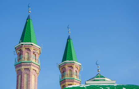 Minarets of mosque with Crescent on blue sky backgroundの写真素材