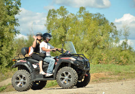 Zelenodolsk, Tatarstan, Russia - June 10, 2015: The married couple is riding on a big black ATV in a summer sunny day.のeditorial素材
