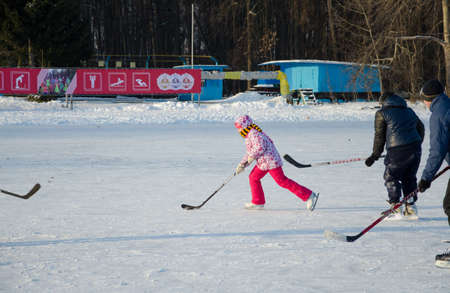 Zelenodolsk, Tatarstan, Russia - January 01, 2016: Girl plays with boys in hockey. Girl on skates for figure skatingのeditorial素材