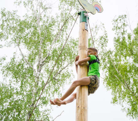 Kazan, Republic of Tatarstan, Russia - May 28, 2016: The boy climbed to the top of a wooden post. Sabantuy (translated from Tatar - feast of the plow) is a traditional celebration of the end of spring field work.のeditorial素材
