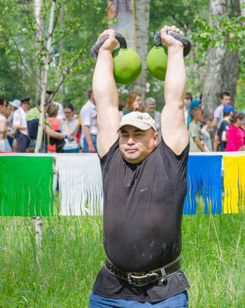 Kazan, Republic of Tatarstan, Russia - May 28, 2016: Male athlete lifts weights. Sabantuy (translated from Tatar - feast of the plow) is a traditional celebration of the end of spring field work.のeditorial素材