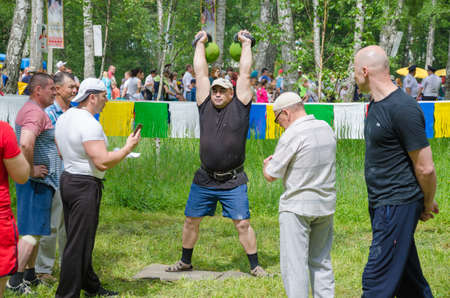 Kazan, Republic of Tatarstan, Russia - May 28, 2016: Male athlete lifts weights. Sabantuy (translated from Tatar - feast of the plow) is a traditional celebration of the end of spring field work.のeditorial素材
