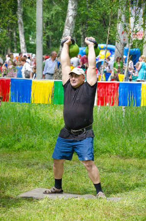 Kazan, Republic of Tatarstan, Russia - May 28, 2016: Male athlete lifts weights. Sabantuy (translated from Tatar - feast of the plow) is a traditional celebration of the end of spring field work.のeditorial素材