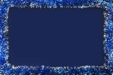 Christmas blue tinsel frame on dark blue backgroundの写真素材