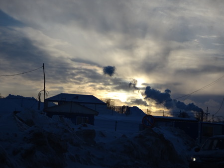 Sunset over city street with dark silhouettes of housesの写真素材