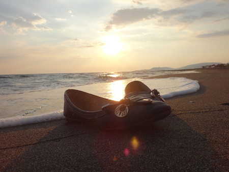 Women's shoes on the beach and sunsetの写真素材
