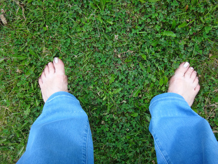 Woman's legs on the ground in summer dayの写真素材