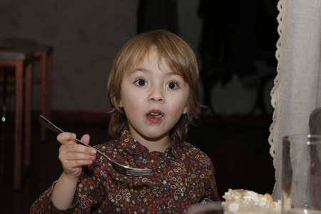 Beautiful little girl with big brown eyes in the cafeの写真素材