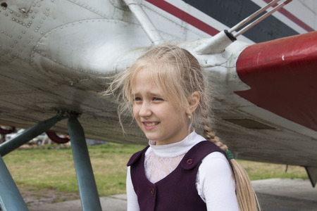 Girl and an old airplane on the airfieldの写真素材