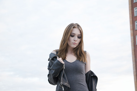 Beautiful girl in grey dress on the roofの写真素材