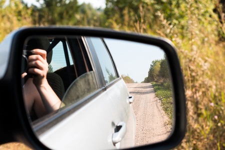 Road reflected in car mirror on a summer day