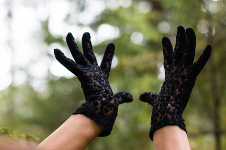Hands in black gloves and nature aroundの写真素材