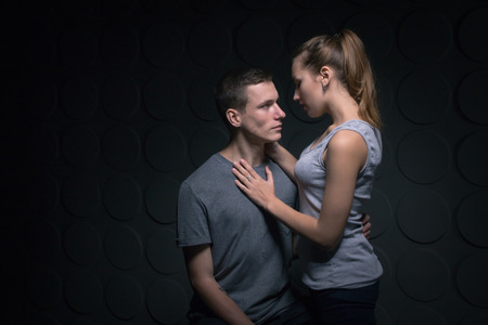 Passionate young couple in the room and the darkness around