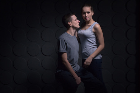 Passionate young couple in the room and the darkness aroundの写真素材