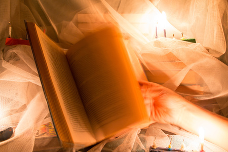 Book and candle light in the darkの写真素材