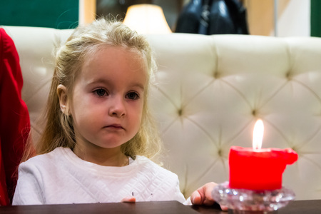 Small girl in white dress in cafeの写真素材