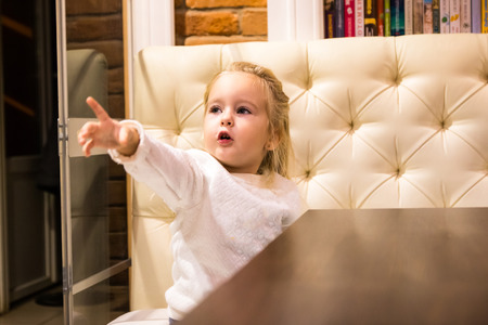 Small girl in white dress in cafeの写真素材