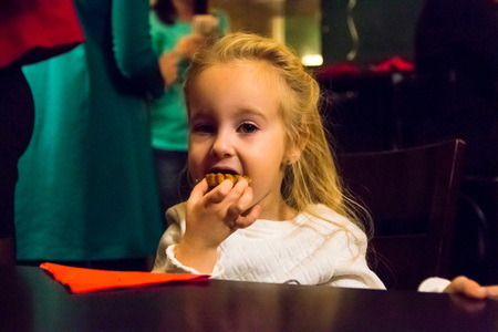 Small girl in white dress in cafeの写真素材