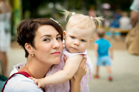 Small cute baby and nice mom outdoorsの写真素材