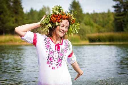 Pretty girl in national dress is in waterの写真素材