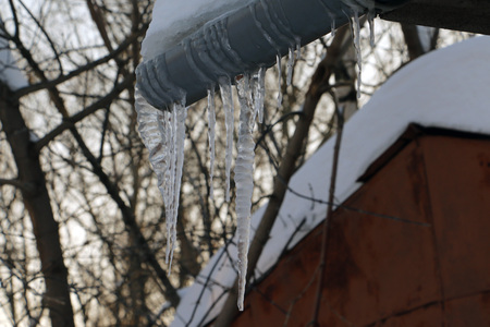 Icicles on the roof in a cold winter dayの写真素材