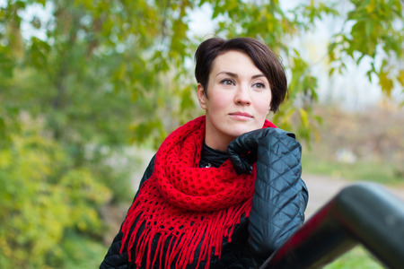 Nice girl in red scarf outdoor in autumn dayの写真素材