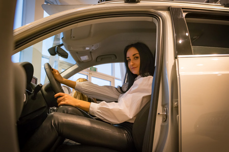 Nice girl in a shop selling car