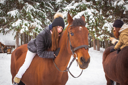 Young girl and horse in a white winter forestの写真素材