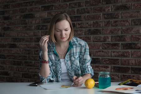 Female artist with blond hair draws in the roomの写真素材