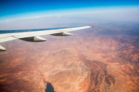 Wing of aeroplane flying in the sky and the earth belowの写真素材