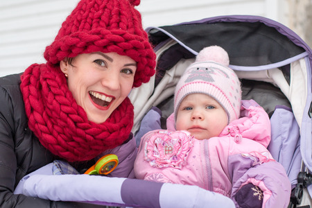 Beautiful mom and nice baby outdor in a winter day
