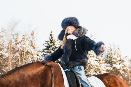 Small girl and horse in a winter dayの写真素材