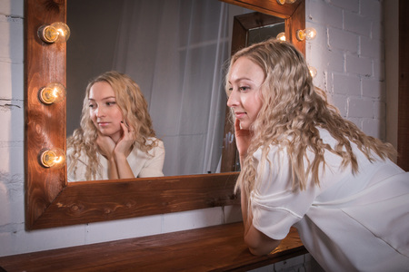 Girl in a pink dress in the room near mirrowの写真素材