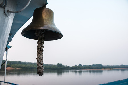 Bell on the ship and the river in the backgroundの写真素材