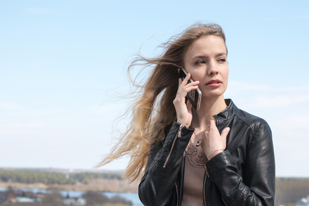 Girl with cell phone and river backgroundの写真素材